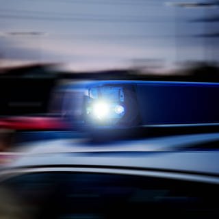 Verwackeltes Blaulicht auf einem schnellfahrenden Polizeifahrzeug im Einsatz. 