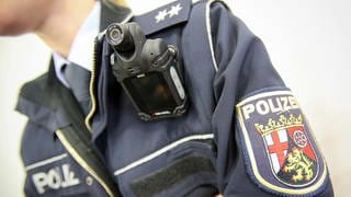 Eine Polizistin aus RLP trägt eine Bodycam. (Symbolbild)