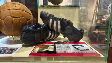 Die letzten getragenen Fußballschuhe von Ottmar Walter in einer Vitrine.