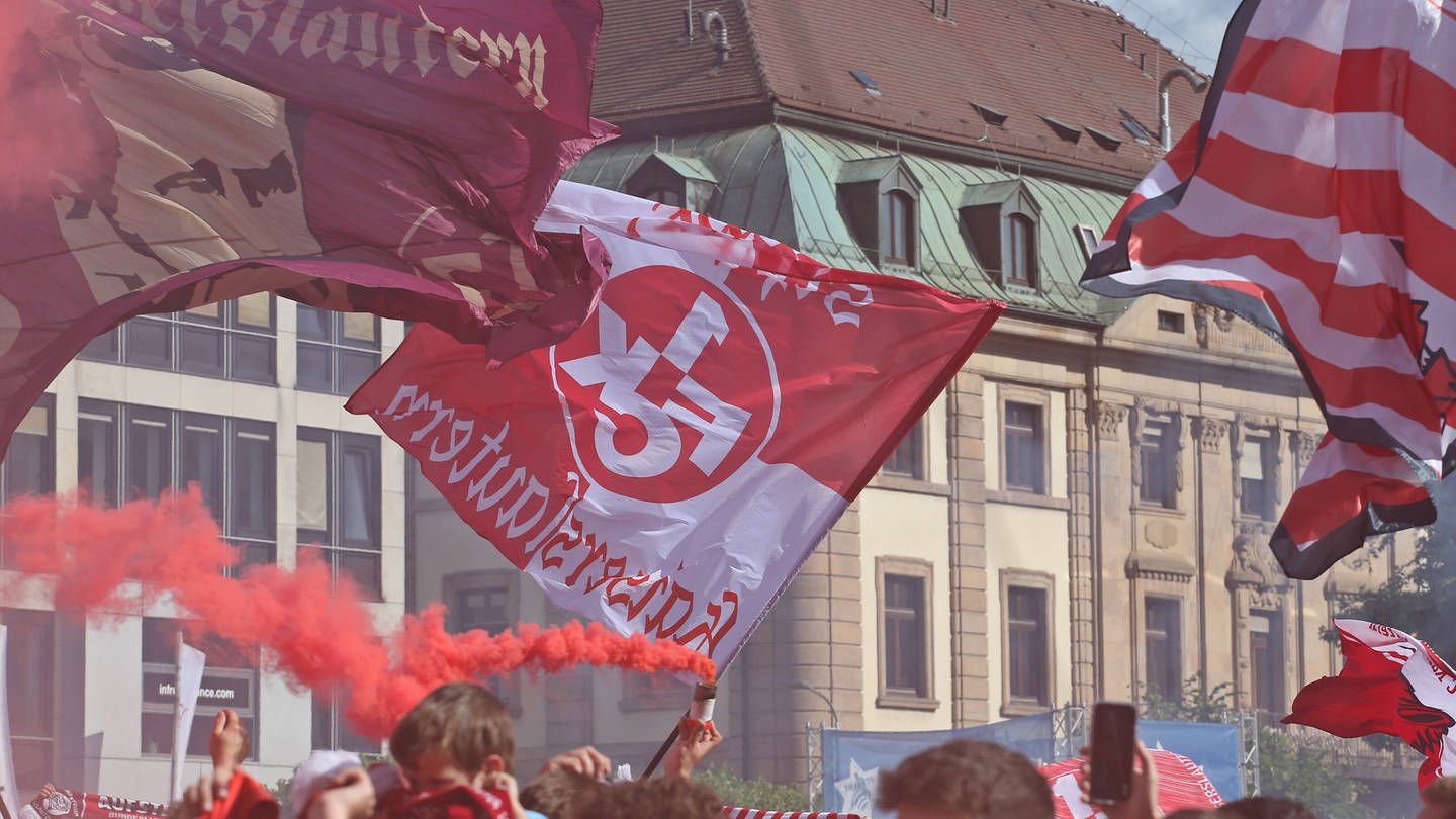 FCK-Fans stehen auf dem Stiftsplatz in Kaiserslautern und schwenken FCK Fahnen, IMAGO/Hübner