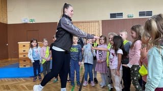 Die Trainerin des Muay-Thai-Vereins aus Marnheim erklärt den Kindern der Zellertal-Schule eine Selbstbehauptungs-Übung.