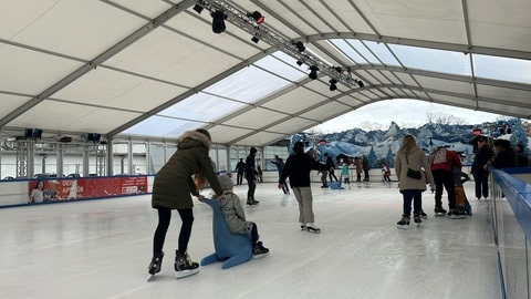 Menschen laufen Schlittschuh auf der Eisbahn in Kaiserslautern