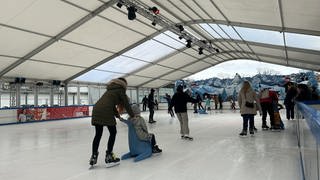 Menschen laufen Schlittschuh auf der Eisbahn in Kaiserslautern