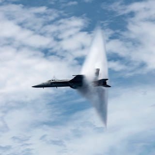 Ein Militär-Flugzeug verursacht einen Überschallknall in der Luft.