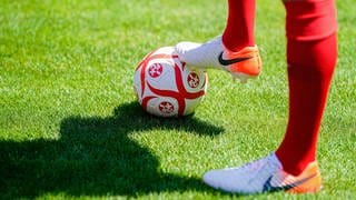 Spieler des FCK hält einen Ball mit Logo unter dem Fuß - Trainingsauftakt des FCK