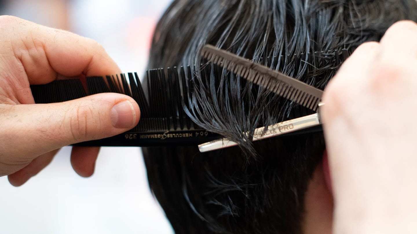Ein Friseur schneidet einem Kunden die Haare. (Symbolbild: picture alliance/dpa | Magdalena Tröndle)