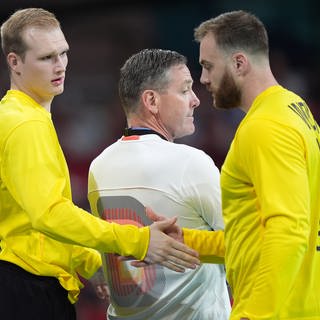 Olympia-Finale Deutschland gegen Dänemark: Torhüter David Späth (l) kommt für Torhüter Andreas Wolff ins Spiel. In der Mitte steht Bundestrainer Alfred Gislason 