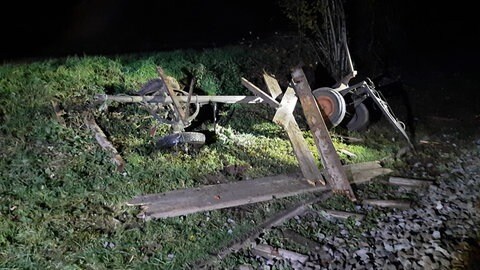 Ein landwirtschaftlicher Anhänger nachdem ein Zug mit ihm zusammengestoßen ist.