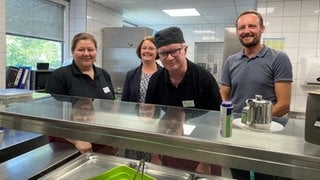 Das Foto zeigt die Küche des SWR-Studios in Kaiserslautern. Links Martina Kalker - Koordinatorin des Gastrobereichs, daneben die stellvertrende Leiterin der Westpfalz-Werkstätten Carolin Witt, Peter Poltz - Mitarbeiter in der SWR-Kantine und rechts steht der Leiter der Werkstätten, Jan Löffler. 