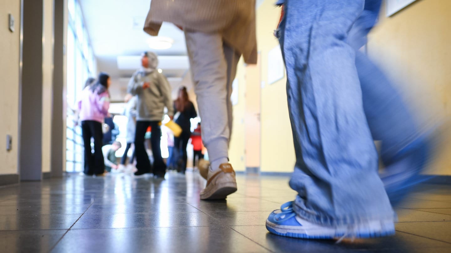 Schüler laufen durch einen Schulgang. Am Hugo-Ball-Gymnasium in Pirmasens soll ein Lehrer einen Schüler geschlagen haben.