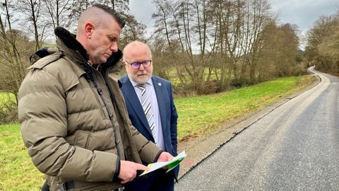 Schauen sich die Pläne für den neuen Radweg am Donnersberg an: Planer Sascha Leib von der Bauverwaltung und Rudolf Jacob (CDU), der Bürgermeister der Verbandsgemeinde Winnweiler.