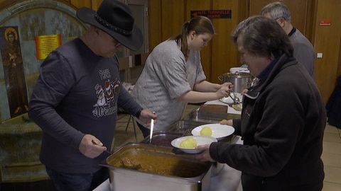 Helfer geben beim Weihnachtsessen für Wohnungslose in Kaiserslautern Klöße, Rotkohl und Gulasch aus.