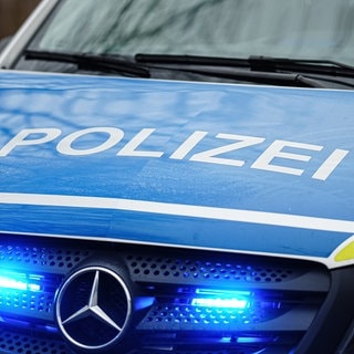 Der Schriftzug "Polizei" steht auf Polizeiauto mit Blaulicht.