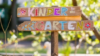 Mit bunter Kreide beschriftetes Kindergarten-Schild.