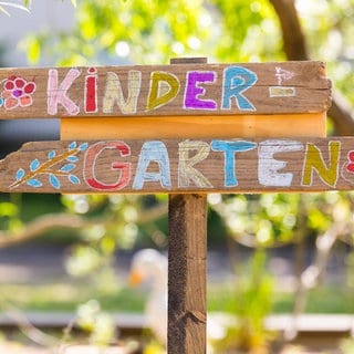 Mit bunter Kreide beschriftetes Kindergarten-Schild.