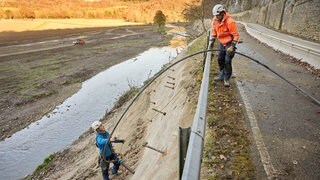 Arbeiter errichten an der Landesstrasse 73 zwischen Insul und Schuld eine Stützmauer zur Ahr hin. 