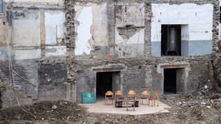 Durch die Flut zerstörtes Haus in Rech, davor stehen Stühle im Halbkreis