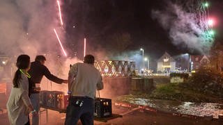 Ahrweiler: Helfer und Betroffene schießen am Ufer der Ahr auf den Resten einer von der Hochwasserkatastrophe zerstörten Brücke Feuerwerkskörper ab.