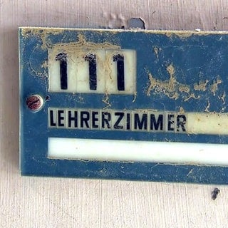 Schlamm an einem Schild mit der Aufschrift "Lehrerzimmer" - 16 Schulen im Landkreis Ahrweiler wurden vom Hochwasser so zerstört, dass sie nach den Sommerferien nicht mehr genutzt werden können.