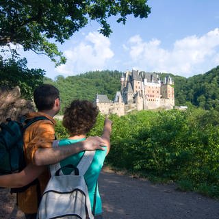 Ein Paar zeigt auf die Burg Eltz