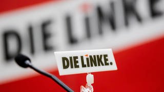 Das Logo der Partei Die Linke ist bei einem Sonderparteitag der Berliner Linken an einem Mikrophon zu sehen. 