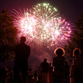Feuerwerk am Himmel mit Menschen im Vordergrund