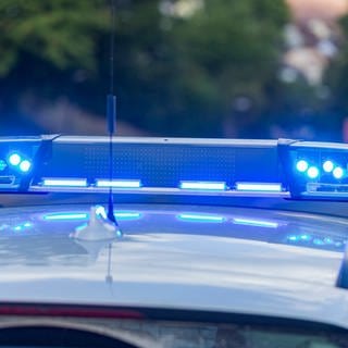 Ein Polizeiwagen steht mit Blaulicht auf einer Straße