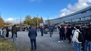 Studierende und Hochschulmitarbeiter stehen auf dem Gelände der Hochschule Koblenz und demonstrieren gegen den geplanten digitalen Lehrbetrieb als Maßnahme zum Energiesparen.
