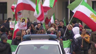 Iranische Demonstranten in Koblenz schwenken Flaggen.