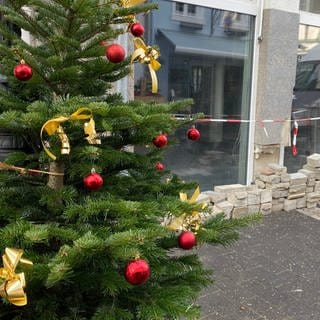 Ein Weihnachtsbaum steht in der Fußgängerzone von Bad Neuenahr-Ahrweiler, in der noch viele Geschäfte von der Flut zerstört sind.