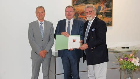 Der Rheinland-Pfälzische Justizminister überreicht Harald Kruse, dem Nachfolger des scheidenden Koblenzer Generalstaatsanwalts Dr. Jürgen Brauer, eine Urkunde