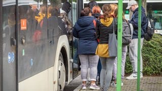 Jugendliche stehen vor einem Bus