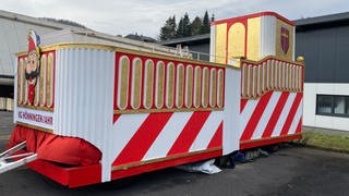 Der neue, gespendete Karnevalswagen der KG Rot-Weiss Hönningen in rot-weiß gestreift mit goldenen Details und mit einem Turm und Wappen verziert