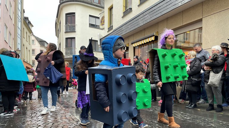 Eltern und Kinder beim Karnevalsumzug in Mayen als Lego-Steine verkleidet