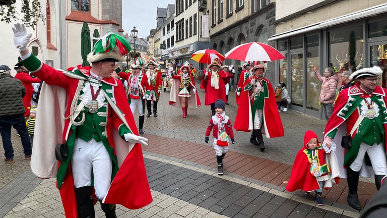 Karnevalisten in grün-roten Uniformen - schon die ganz Kleinen laufen mit.