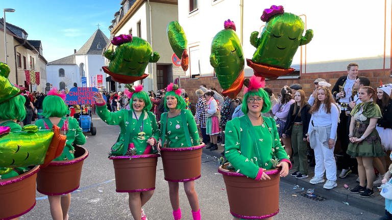 Eine Frauen-Fußgruppe läuft verkleidet als Kakteen durch die Straßen