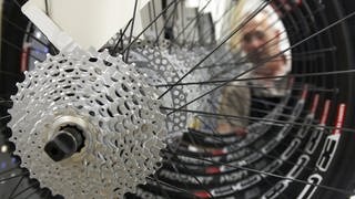 Hinterräder eines Fahrrads der Marke Canyon werden von einem Mitarbeiter begutachtet