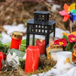 Kerzen und Blumen liegen in einem Wald im südlichen Nordrhein-Westfalen, wo das getötete zwölfjährige Mädchen Luise aufgefunden wurde