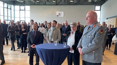 Mehrere Menschen stehen in der Bundeswehr Kaserne in Koblenz nebeneinander