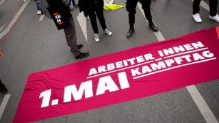 Bundeskanzler Olaf Scholz (SPD) wird am 1. Mai bei der DGB Kundgebung am Deutschen Eck in Koblenz erwartet. Demonstrant mit Transparent Arbeiter:innen Kampftag auf einer Demonstration.