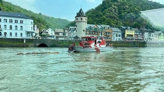 Das mit Wasser vollgeschlagene Ruderboot bei Sankt Goar, daneben ein Einsatzboot der Feuerwehr