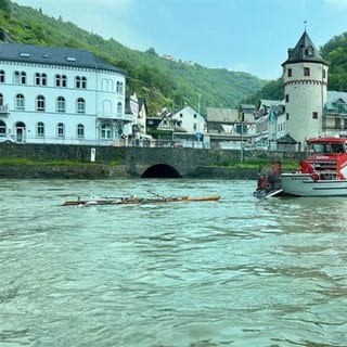 Das mit Wasser vollgeschlagene Ruderboot bei Sankt Goar, daneben ein Einsatzboot der Feuerwehr