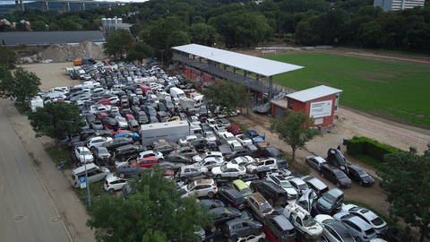 Schrottautos türmen sich auf dem Parkplatz des Apollinaris-Stadions in Bad Neuenahr.