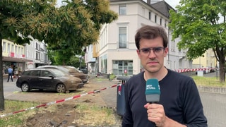 SWR-Reporter Michael Eiden vor dem Friseursalon in Neuwied, in den heute ein Frau mit ihrem Auto gefahren ist.