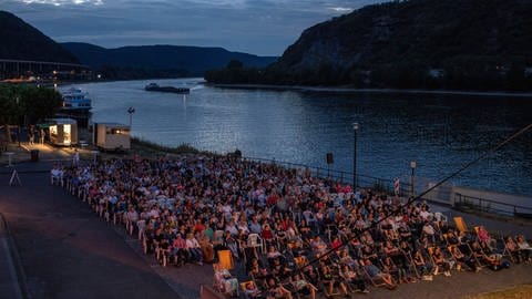 Open-Air-Kino in Andernach: Hunderte Menschen sitzen vor einer Leinwand am Rhein