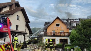 Feuerwehrleute löschen einen Dachstuhlbrand in einem Hotel in Obersteinebach im Kreis Altenkirchen