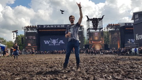 Christian steht im Matsch vor der Bühne beim Wacken Festival