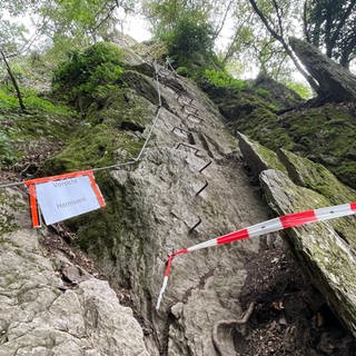 Ein Teil des Klettersteiges in Boppard ist mit rot weißem Flatterband abgesperrt, ein Schild warnt vor Hornissen.
