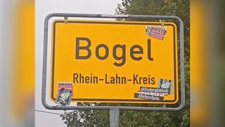 Ortsschild der Gemeinde Bogel im Rhein-Lahn-Kreis mit Stickern beklebt