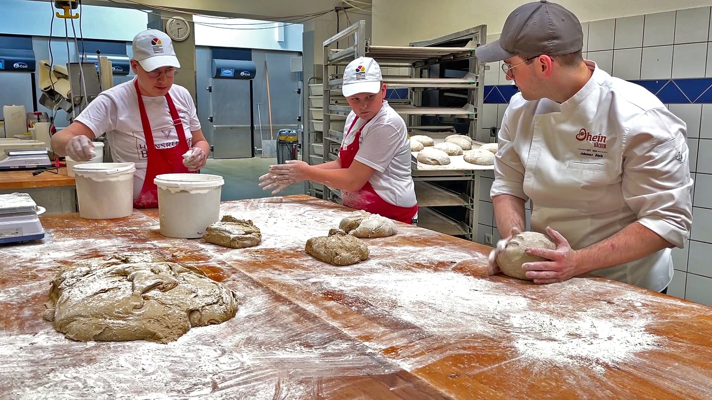 Clemens Wiede und Janic Schmitt lernen bei Bäckermeister Johannes Dhein, wie man Sauerteig-Brot backt